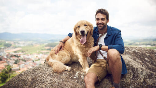 barbat cu un Golden Retriever pe o stanca